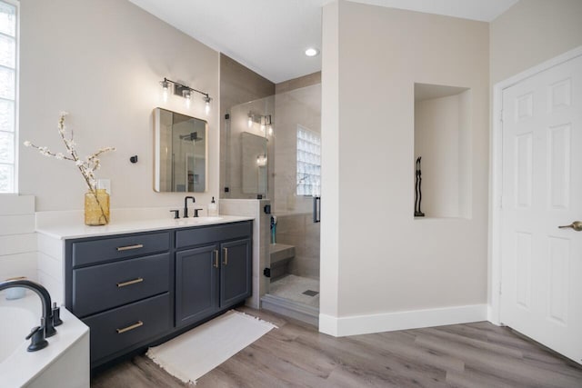 bathroom with vanity, wood-type flooring, and plus walk in shower