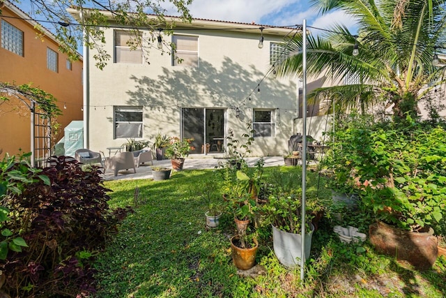 rear view of property with a lawn and a patio