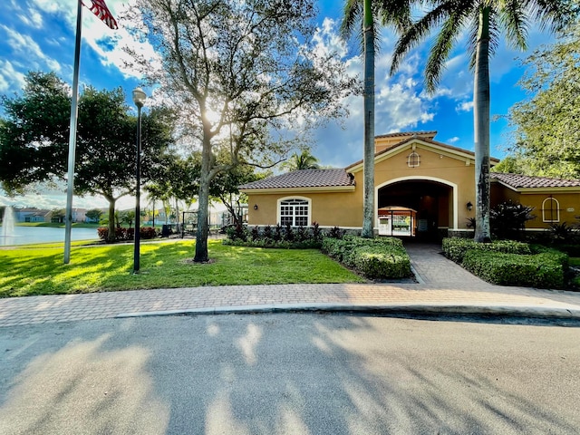 mediterranean / spanish-style house featuring a water view and a front yard