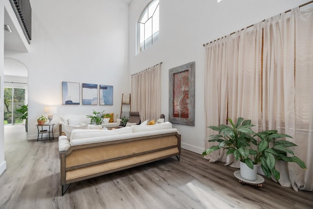 bedroom featuring a high ceiling, multiple windows, and hardwood / wood-style floors