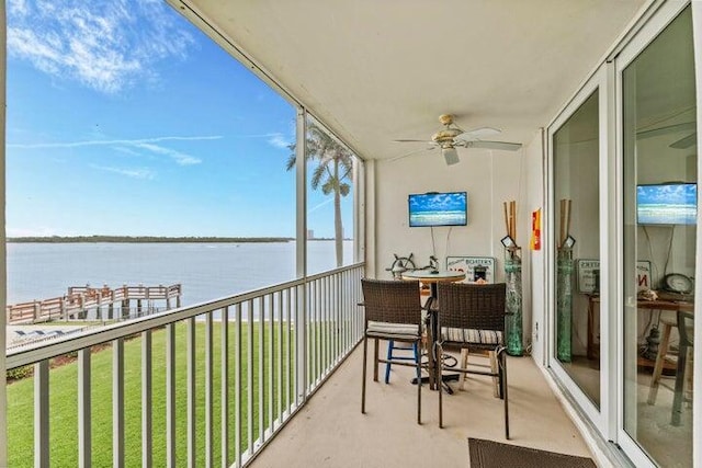 balcony with ceiling fan and a water view