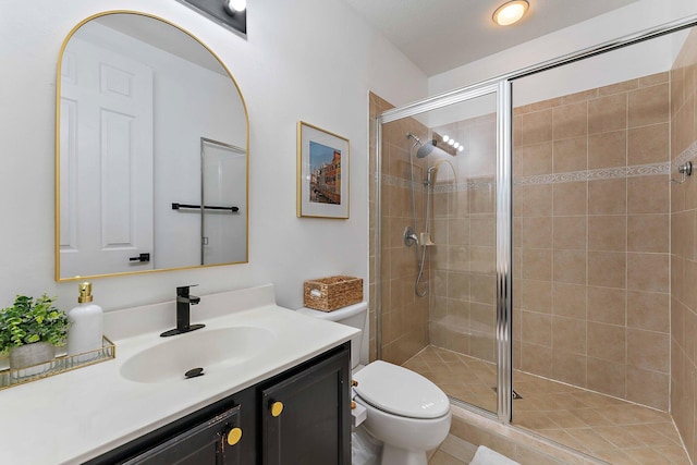 bathroom with tile patterned flooring, a shower with door, vanity, and toilet