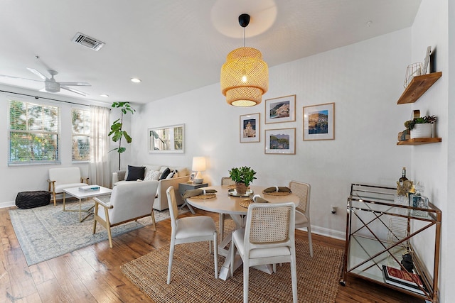 dining area with ceiling fan and wood-type flooring