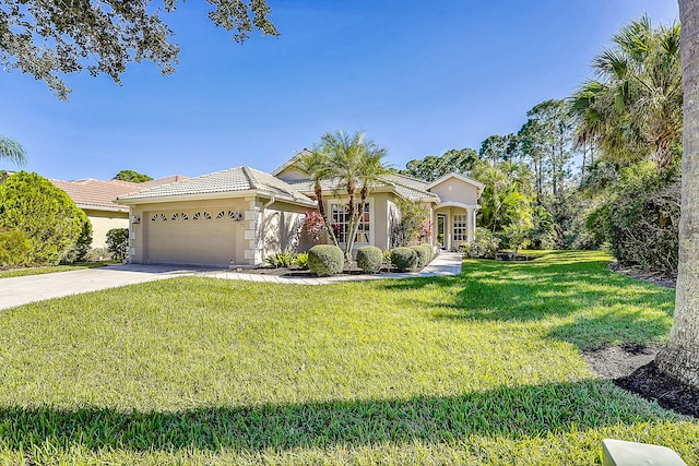 mediterranean / spanish-style home with a garage, a front yard, and french doors