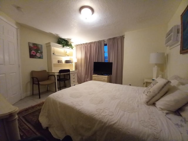 bedroom featuring a textured ceiling and a wall mounted AC