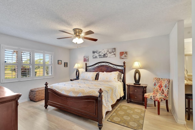 bedroom featuring ceiling fan, light wood-type flooring, and a textured ceiling