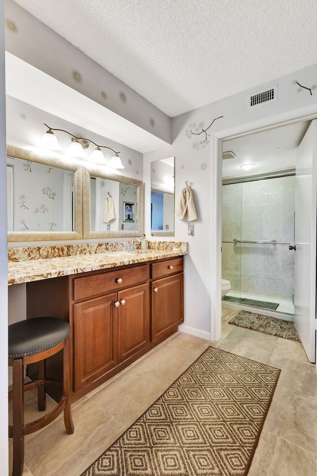 bathroom with walk in shower, tile patterned floors, a textured ceiling, toilet, and vanity