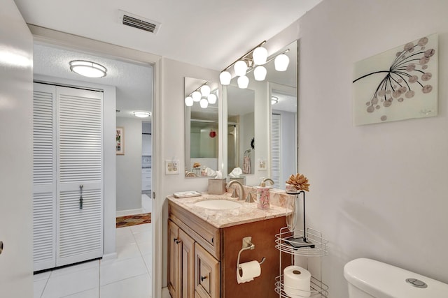 bathroom featuring toilet, vanity, and tile patterned floors