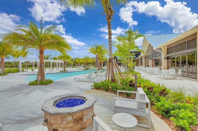 view of swimming pool with a patio and a fire pit