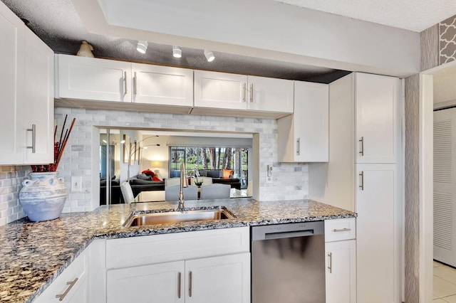 kitchen featuring white cabinets, dishwasher, decorative backsplash, and sink