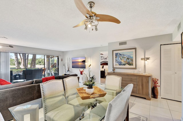 dining area featuring a textured ceiling, ceiling fan, and light tile patterned flooring