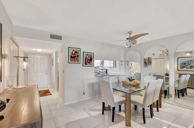 tiled dining space featuring ceiling fan and a textured ceiling