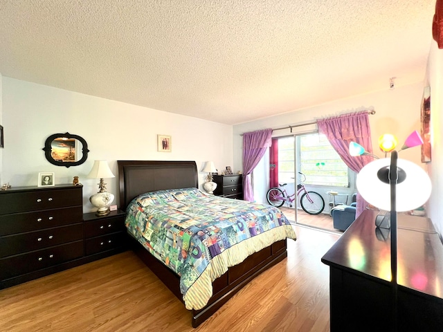 bedroom with a textured ceiling and light wood-type flooring