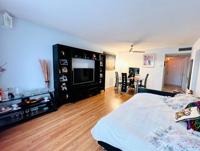 bedroom featuring hardwood / wood-style floors, a textured ceiling, and ceiling fan