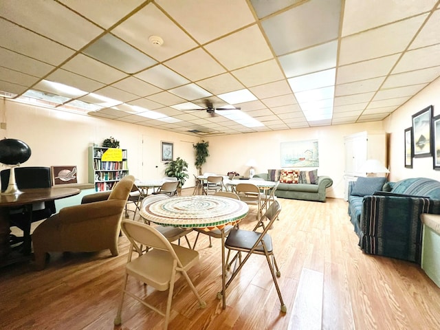 dining area with ceiling fan, light hardwood / wood-style flooring, and a drop ceiling