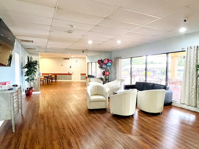 living room featuring a paneled ceiling and hardwood / wood-style floors