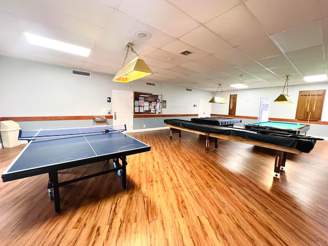 game room with a paneled ceiling, wood-type flooring, and pool table