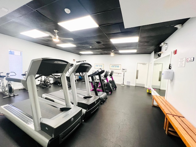 gym featuring a drop ceiling and ceiling fan