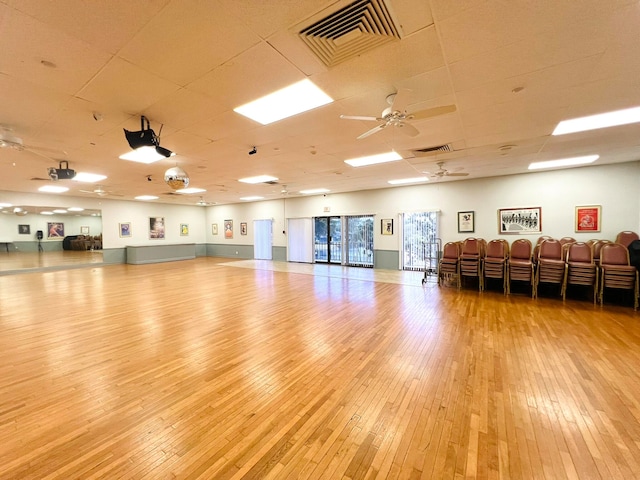 exercise room featuring ceiling fan and light wood-type flooring