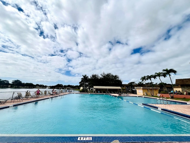 view of swimming pool with a water view and a patio