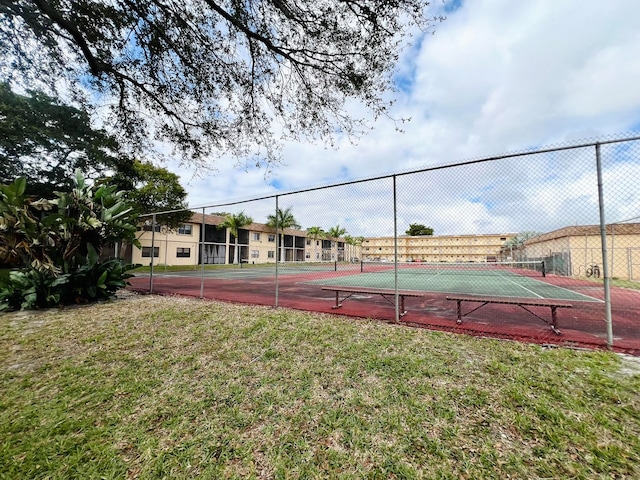 view of tennis court featuring a lawn