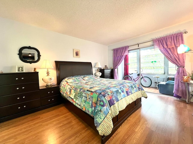 bedroom with a textured ceiling and light wood-type flooring