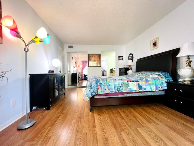 bedroom featuring light hardwood / wood-style floors and a textured ceiling