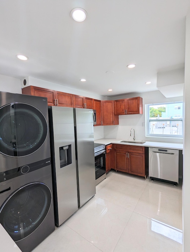 kitchen featuring light tile patterned flooring, sink, stacked washer and dryer, and stainless steel appliances