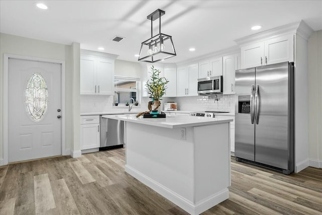 kitchen with white cabinetry, stainless steel appliances, and a kitchen island