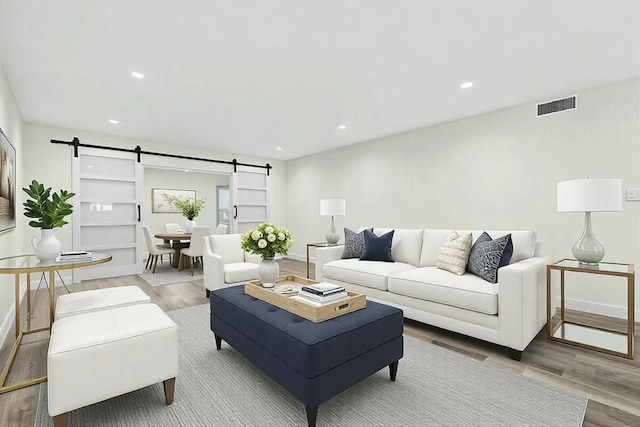 living room featuring a barn door and light wood-type flooring