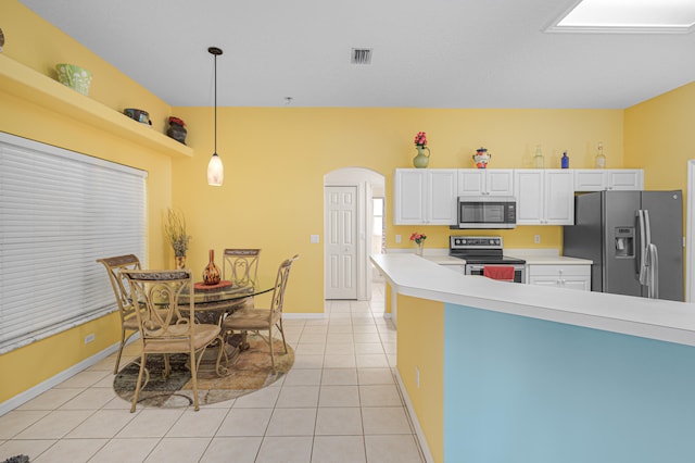 kitchen with white cabinetry, hanging light fixtures, light tile patterned floors, and stainless steel appliances