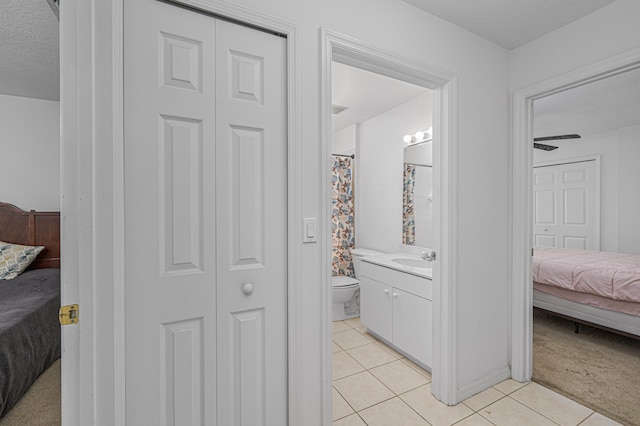 bathroom with tile patterned floors, vanity, toilet, and a textured ceiling