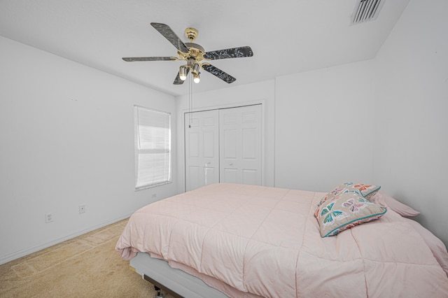 carpeted bedroom featuring a closet and ceiling fan