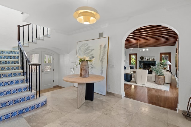 foyer entrance with beam ceiling, light hardwood / wood-style floors, french doors, and ornamental molding