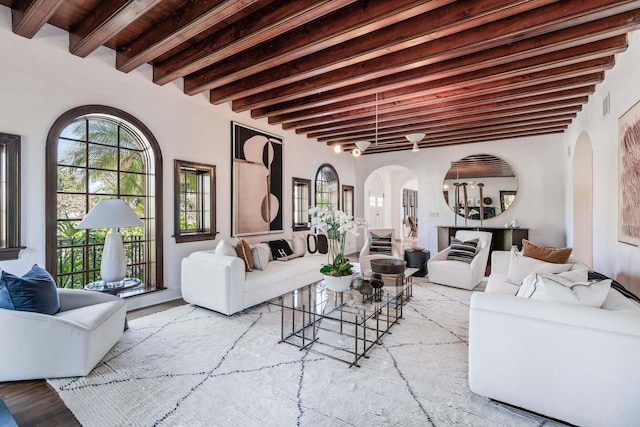 living room featuring beamed ceiling and light hardwood / wood-style flooring