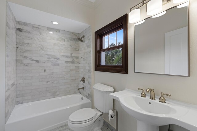 full bathroom featuring tiled shower / bath combo, toilet, crown molding, and sink