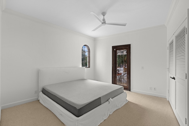 carpeted bedroom with ceiling fan, crown molding, and a closet