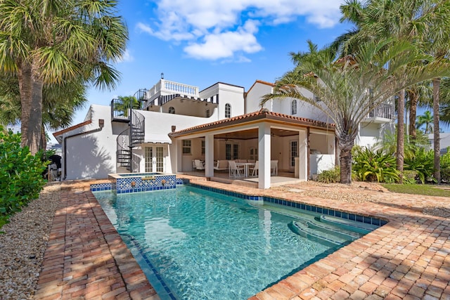 view of swimming pool featuring ceiling fan, a patio area, and an in ground hot tub