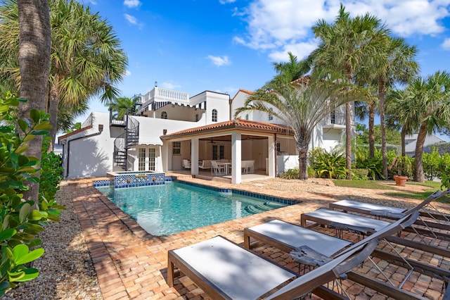 view of swimming pool featuring ceiling fan, a patio, and an in ground hot tub