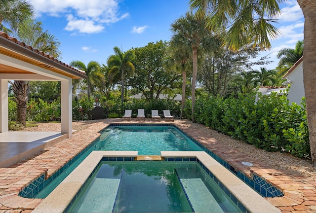 view of pool with an in ground hot tub