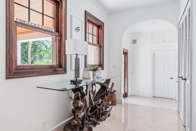 hallway with light tile patterned floors and ornamental molding