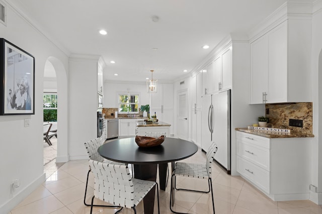 dining room featuring light tile patterned floors, crown molding, and sink