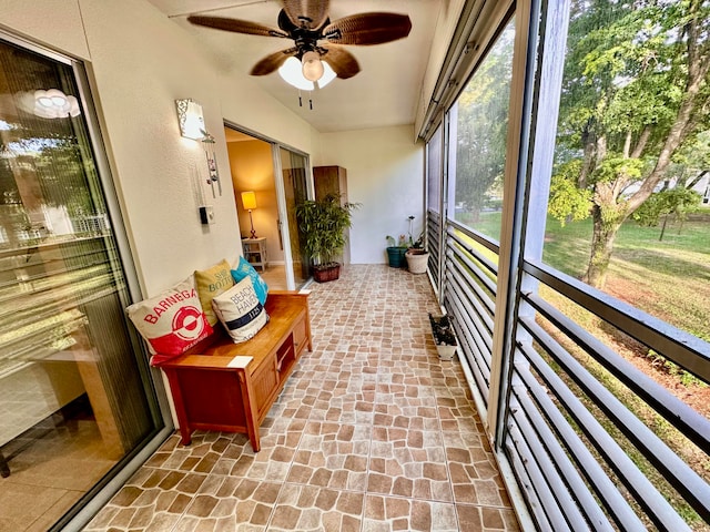 unfurnished sunroom with ceiling fan