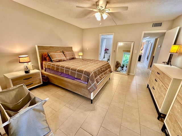 tiled bedroom with ceiling fan and a textured ceiling