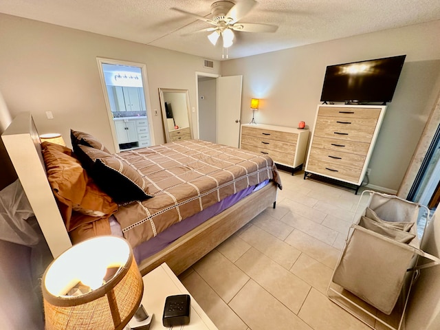 bedroom with ensuite bathroom, ceiling fan, light tile patterned floors, and a textured ceiling