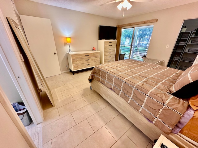 bedroom featuring ceiling fan, light tile patterned floors, and a textured ceiling