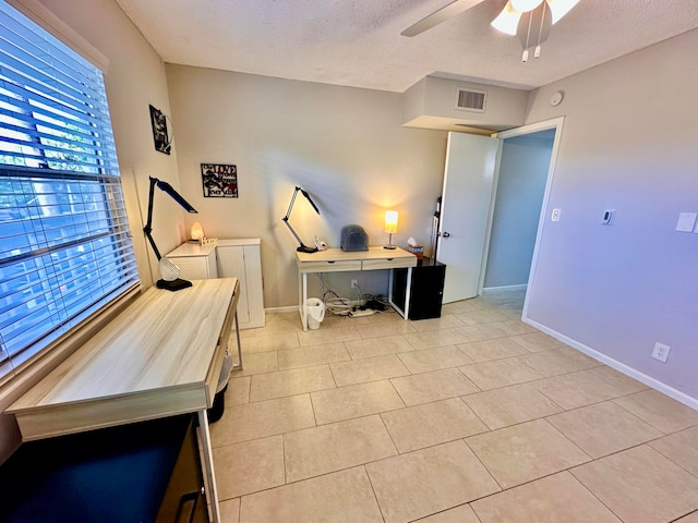 office featuring ceiling fan, light tile patterned floors, and a textured ceiling