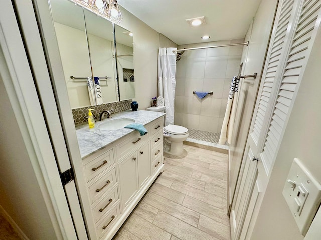 bathroom with tasteful backsplash, a shower with curtain, wood-type flooring, toilet, and vanity