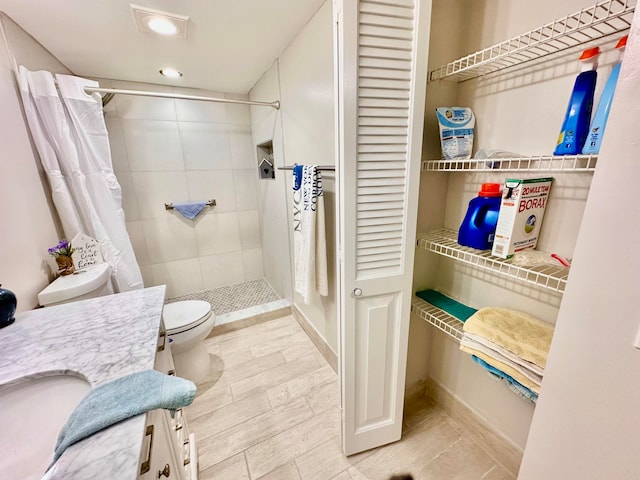 bathroom with curtained shower, vanity, and toilet