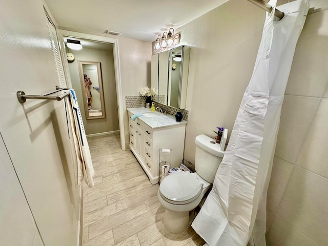 bathroom with vanity, toilet, and wood-type flooring